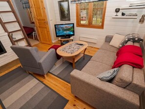 Relax in this inviting living room with a comfortable sofa, armchair, and flat-screen TV.