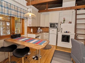 Cozy cabin kitchen with a wooden countertop, island, and bar stools.