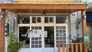 A wooden structure with a signboard, a wooden bench, and potted plants. - Green Stay (Hengchun)