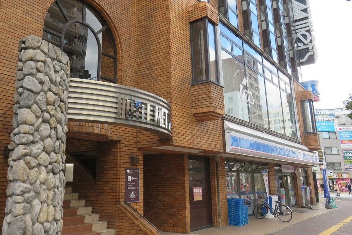 A hotel with a stone pillar, a staircase, and a sign with Chinese characters.