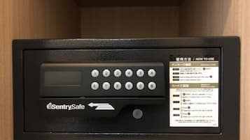 En sort elektronisk enhed med tastefelt og skærm, mærket 'SentrySafe', i et træskab.