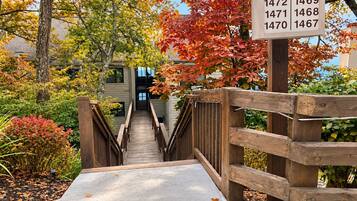 A wooden staircase leading to a building with a sign displaying apartment numbers.