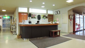 A reception area with a counter, a small stool, and a refrigerator. - Kurion (Senboku)