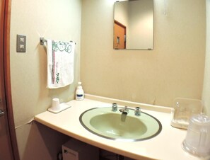 A bathroom with a sink, mirror, towel, soap dispenser, and a cup. - Kurion (Senboku)