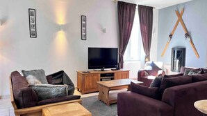 A living room with a TV, sofas, a coffee table, and a fireplace. - STUNNING FRENCH HOUSE, SPACIOUS AND WELL EQUIPPED - SLEEPS 10 (Le Bourg-d'Oisans)