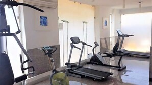 A gym with treadmills, an elliptical, and a stationary bike. - Sea view Serviced Apartment 2 bedroom 2 bath #1 (Hawally)