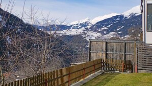 A wooden cabin with a view of snow-capped mountains.