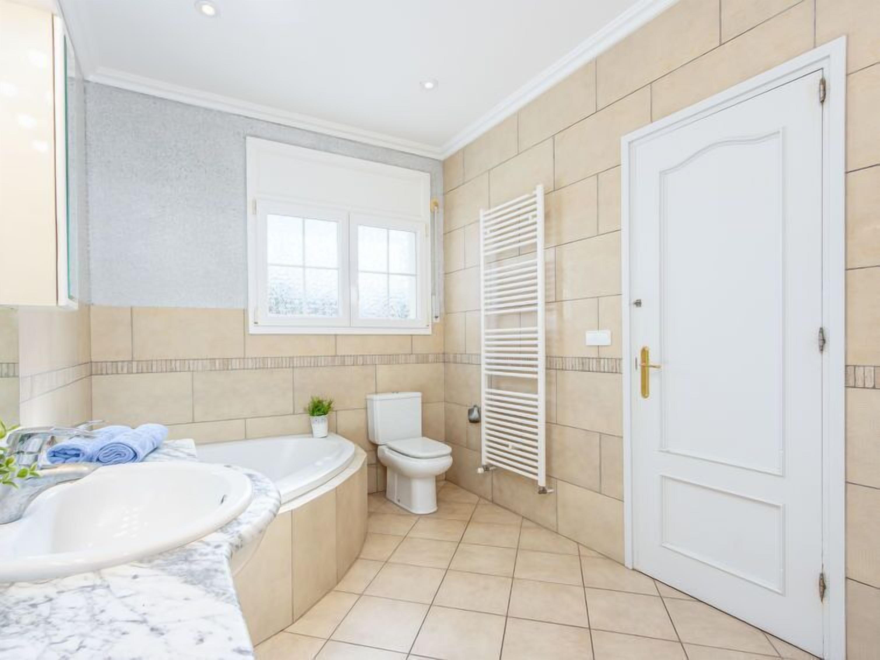 Ein Badezimmer mit Badewanne, Toilette und Waschbecken.