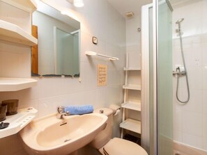 A bathroom with a sink, toilet, and glass-enclosed shower. - Vacation home Club by Interhome (Calonge)