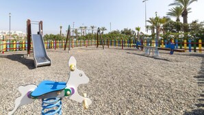 A playground with a slide, swings, and a climbing structure.