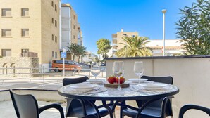 An outdoor dining area with a round table set for two, surrounded by black chairs. - Platja de Roses by Interhome (Roses)