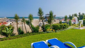 Une vue sur la plage avec des chaises longues et des palmiers.