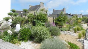 A garden with various plants and a stone wall. - Le Ménez by Interhome (Penmarc'h)