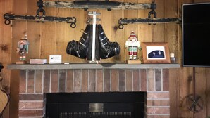 A fireplace with a rustic wooden mantel, a metal coat rack, and a framed picture. - Snowshed & Ramshead Ski Lodges in walking distance plus shuttle service (Killington)