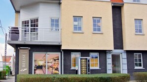 Een gebouw met twee verdiepingen, met een bakkerij genaamd 'BELISE' op de begane grond.