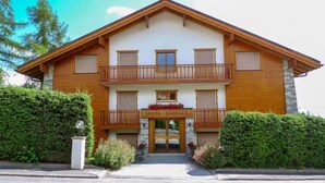 A two-story building with a wooden facade, balconies, and a sign reading "SANTA BARBARA." - Santa Barbara 23 by Interhome (Crans-Montana)