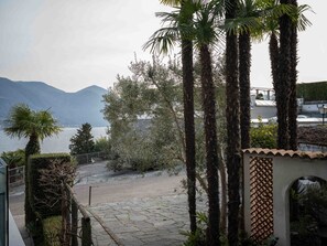 Une vue sur la côte, avec des palmiers, un sentier en pierre et une montagne en arrière-plan.