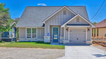 A two-story house with a garage, a front porch, and a well-maintained lawn.
