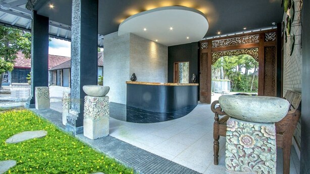 A reception area with a curved counter, stone pillars, and a decorative entrance. - Villa 6# 1BR Stunning Villa w/ Public pool at downtown Ubud (Ubud)