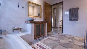 A bathroom with a bathtub, a sink with a wooden cabinet, a mirror, and a shower area. - Villa 6# 1BR Stunning Villa w/ Public pool at downtown Ubud (Ubud)