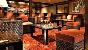 A bar area with wicker furniture, a patterned carpet, and a bar stocked with bottles. - JAZ Crown Jubilee Nile Cruise - Every Thursday from Luxor for 07 & 04 Nights - Every Monday from Aswan for 03 Nights (Luxor)
