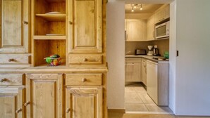 Une cuisine avec des meubles de rangement en bois, un four à micro-ondes et un grille-pain.