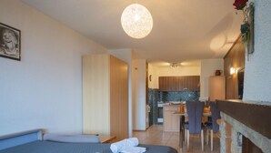 Hotellihuone, jossa on sänky, työpöytä ja pieni keittiönurkkaus.