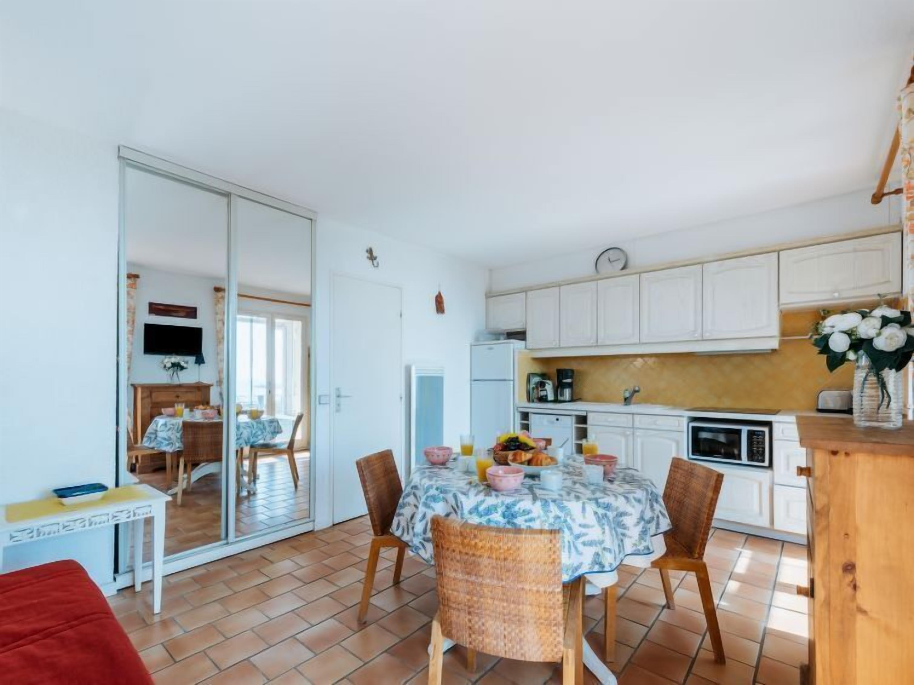 A compact living space with a dining area, kitchenette, and a sliding glass door leading to an adjacent room.