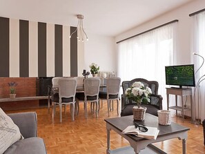A modern living room with a dining area, a television, and a fireplace. - Penthouse Suite by Interhome (Ascona)