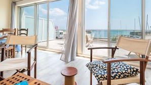 Un balcon donnant sur la mer, aménagé avec des chaises et une table.