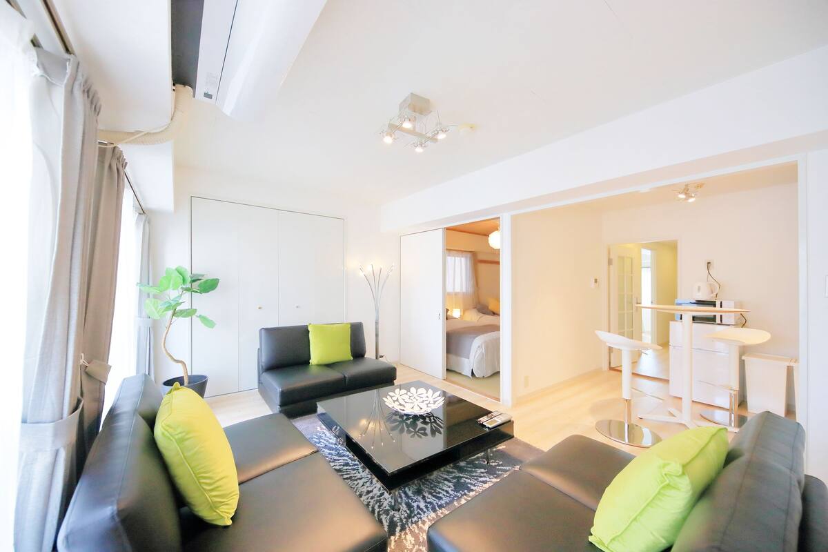 A modern living room with a sofa, a coffee table, and a potted plant.