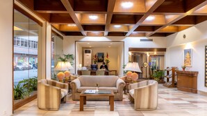 A lobby with a sofa, armchairs, a coffee table, and a reception desk. - The Malla Hotel (Kathmandu)
