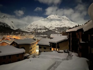 A snow-covered mountain with a town in the foreground.