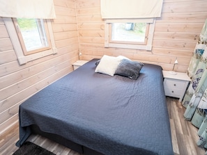 Una stanza con un letto, un comodino e una finestra con tende.
