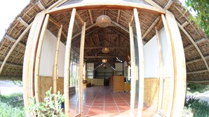 A spacious room with a high ceiling and a thatched roof structure.