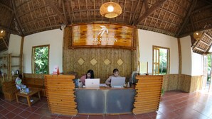 A reception desk at Trenguon Hotel & Resort with two staff members at their computers.