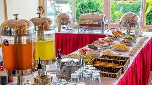 A buffet table with various food items and beverage dispensers.