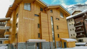 Un edificio in legno con la scritta 'Chalet Rutsch' sulla facciata, circondato dalla neve.