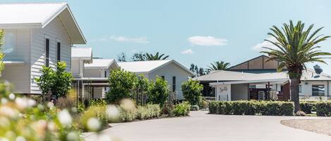 A modern hotel with a central courtyard, surrounded by white buildings and lush greenery.