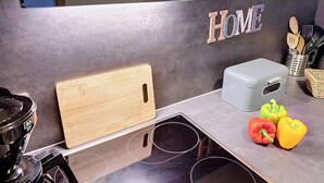 A kitchen with a wooden cutting board, a stove, and a 'HOME' sign on the wall.