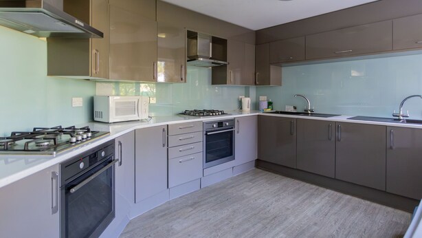 A modern kitchen with stainless steel appliances, a built-in oven, and a microwave. - University Campus Park Wood by Interhome (Canterbury)