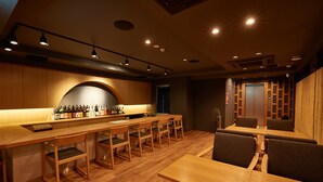 A modern bar area with wooden furniture and a long counter. - KAMAKURA Hotel (Kamakura)