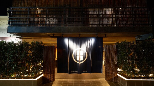 A hotel entrance with a dark facade, a visible logo, and a tiled floor. - KAMAKURA Hotel (Kamakura)