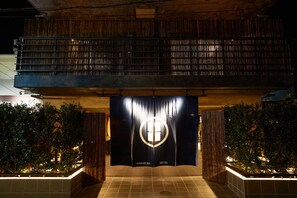 A hotel entrance with a dark facade, a visible logo, and a tiled floor. - KAMAKURA Hotel (Kamakura)