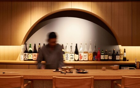 A restaurant with wooden walls and a long table set for dining.