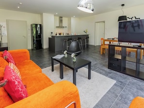A modern living room with a sofa, a coffee table, and a TV.