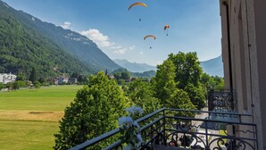 A balcony with a view of a mountainous landscape, a green field, and a clear sky. - Apartment Modern by Interhome (Interlaken)