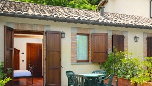 A traditional building with a tiled roof, wooden shutters, and a patio area with a table and chairs. - Montecorneo by Interhome (Perugia)