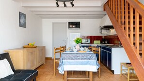Une cuisine de taille réduite avec un coin repas, des meubles en bois et un escalier.