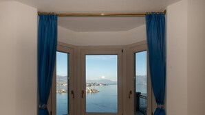 Quarto de canto com vista para um lago e montanhas.
